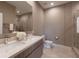 Modern bathroom featuring dual sinks, sleek vanity, and a glass-enclosed shower with stylish tile work at 7461 Bleecker Ln, Kissimmee, FL 34747