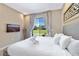 Bright bedroom featuring a king bed, flat-screen TV, and sliding glass doors overlooking the community lawn at 7461 Bleecker Ln, Kissimmee, FL 34747
