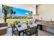 Outdoor dining area featuring a grill, granite counter and seating, with views of the manicured lawn at 7461 Bleecker Ln, Kissimmee, FL 34747