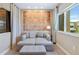 Cozy sitting area features a comfortable daybed, ottoman, and large windows for natural light at 7461 Bleecker Ln, Kissimmee, FL 34747