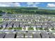 Aerial view showcases a neighborhood with lush green spaces and a lake in the background on a bright sunny day at 7639 Agrigento St, Clermont, FL 34714