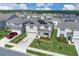 Aerial view of a two-story home with solar panels in a suburban neighborhood with green lawns and trees at 7639 Agrigento St, Clermont, FL 34714