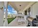 Inviting covered back patio with rocking chairs, grill and landscaped backyard at 7639 Agrigento St, Clermont, FL 34714