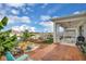 Inviting covered back patio with wood flooring, summer kitchen, waterfall feature and landscaped backyard at 7639 Agrigento St, Clermont, FL 34714