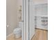 Bathroom with toilet and open door to a large walk-in closet with built-in shelving at 7639 Agrigento St, Clermont, FL 34714