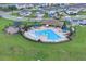 Aerial view of community pool area with clubhouse, splashpad, and playground at 7639 Agrigento St, Clermont, FL 34714