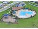 Aerial view of community pool area with clubhouse, playground, and lounge chairs at 7639 Agrigento St, Clermont, FL 34714