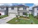 Inviting two-story home featuring a front lawn with meticulous landscaping and a two car garage at 7639 Agrigento St, Clermont, FL 34714