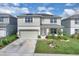 Charming two-story home with a well-manicured lawn and solar panels on the roof under a bright blue sunny sky at 7639 Agrigento St, Clermont, FL 34714