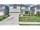 Charming two-story home with a well-manicured lawn, solar panels, a two-car garage, and a welcoming front porch at 7639 Agrigento St, Clermont, FL 34714