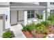 Inviting front porch with a comfortable white sofa and fresh landscaping adds charm to the home's exterior at 7639 Agrigento St, Clermont, FL 34714