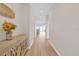 Bright hallway with light wood floors leading to a well-lit living area with views of the outdoors at 7639 Agrigento St, Clermont, FL 34714