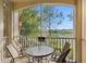 Screened balcony with seating overlooking a serene lake view at 7660 Comrow St # 203, Kissimmee, FL 34747
