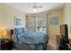Bedroom with a queen size bed, soft lighting, and a corner window at 7660 Comrow St # 203, Kissimmee, FL 34747