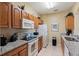 Well-lit kitchen with granite countertops, wooden cabinets, and modern appliances at 7660 Comrow St # 203, Kissimmee, FL 34747