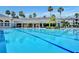Large community pool with palm trees and a clubhouse at a resort-style complex, perfect for relaxation and recreation at 8168 Boat Hook Loop # 201/718, Windermere, FL 34786