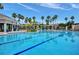 Resort-style community pool with palm trees and pergola covered lounge areas, perfect for relaxation and recreation at 8168 Boat Hook Loop # 201/718, Windermere, FL 34786