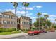 Condo complex with palm trees, well-kept landscaping, and dedicated parking at 8168 Boat Hook Loop # 201/718, Windermere, FL 34786