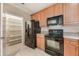 Bright kitchen featuring black appliances, granite countertops and wood cabinets at 8168 Boat Hook Loop # 201/718, Windermere, FL 34786
