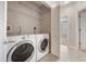 A laundry room featuring washer and dryer with open shelving and a view to a bedroom at 8168 Boat Hook Loop # 201/718, Windermere, FL 34786