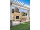 Outdoor fireplace and seating area with a wooden bench and lush green grass at 8168 Boat Hook Loop # 201/718, Windermere, FL 34786