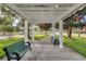 Outdoor seating area with a pergola, benches, and green lawns at 8168 Boat Hook Loop # 201/718, Windermere, FL 34786