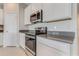 Bright kitchen features white cabinetry, modern appliances, and quartz countertops at 865 Citrus Reserve Blvd, Davenport, FL 33837