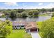 Aerial view of a home with a scenic waterfront view, solar panels, screened-in patio, and a lush green lawn at 930 Chickadee Dr, Port Orange, FL 32127