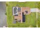 Aerial view of a home with a pool, expansive solar panels, a well-maintained lawn, and a cozy outdoor cabana at 930 Chickadee Dr, Port Orange, FL 32127
