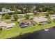 Aerial view of a waterfront home with a pool, dock, solar panels, and lush green lawn in a residential neighborhood at 930 Chickadee Dr, Port Orange, FL 32127