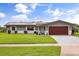 Charming single-story home with a well-manicured lawn, solar panels, and an attached two-car garage at 930 Chickadee Dr, Port Orange, FL 32127