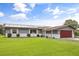 Charming single-story home with a well-manicured lawn, solar panels, and an attached two-car garage at 930 Chickadee Dr, Port Orange, FL 32127