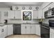 Modern kitchen with white cabinetry, granite countertops, stainless steel appliances, and tile flooring at 930 Chickadee Dr, Port Orange, FL 32127