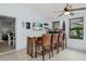 Bright living room featuring a bar area, tile flooring, and a ceiling fan at 930 Chickadee Dr, Port Orange, FL 32127