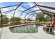 A screened-in pool features an outside view of the water, enhancing the appeal of the property at 930 Chickadee Dr, Port Orange, FL 32127