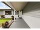 Charming covered porch with gray flooring, white brick accents, and lush landscaping leading to the front door at 930 Chickadee Dr, Port Orange, FL 32127