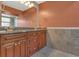 Bathroom features granite countertop, twin sinks, and stylish tile backsplash at 9319 Woodbreeze Blvd, Windermere, FL 34786
