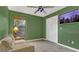 Relaxing bedroom features green walls, a large window, and a loveseat for seating at 9319 Woodbreeze Blvd, Windermere, FL 34786