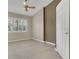 A naturally lit bedroom features a ceiling fan, neutral paint, and tile floors at 9319 Woodbreeze Blvd, Windermere, FL 34786