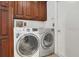 A well-equipped laundry room features a washer, dryer, and cabinetry at 9319 Woodbreeze Blvd, Windermere, FL 34786