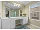 Bathroom with dual sinks, vanity, and large mirror with shower, lots of natural light at 934 Rock Harbor Ave, Orlando, FL 32828