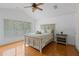 Bright bedroom featuring a cozy bed, hardwood floors, and a large window at 934 Rock Harbor Ave, Orlando, FL 32828