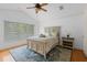 Bright bedroom featuring a cozy bed, hardwood floors, and a large window with rug at 934 Rock Harbor Ave, Orlando, FL 32828