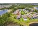 Aerial view showing the home's well-manicured lawn, neighboring houses, water views and the community's lush surroundings at 9844 Beach Port Dr, Winter Garden, FL 34787