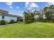 Manicured backyard featuring lush green grass, garden beds, and privacy hedges, perfect for outdoor activities at 9844 Beach Port Dr, Winter Garden, FL 34787