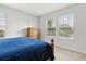 This bedroom has an abundance of natural light with two windows and a wooden dresser at 9844 Beach Port Dr, Winter Garden, FL 34787
