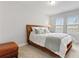 Comfortable bedroom with a wood frame bed, soft carpet, and natural light from the windows at 9844 Beach Port Dr, Winter Garden, FL 34787