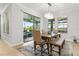 Bright dining area featuring a wood table, chandelier, and sliding glass door to an outdoor living space at 9844 Beach Port Dr, Winter Garden, FL 34787