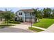 Two-story home with a brick driveway, a two-car garage, manicured landscaping, and a well-maintained lawn at 9844 Beach Port Dr, Winter Garden, FL 34787