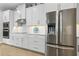 Modern kitchen featuring built-in appliances, white cabinetry, marble countertops, subway backsplash, and stainless steel appliances at 9844 Beach Port Dr, Winter Garden, FL 34787